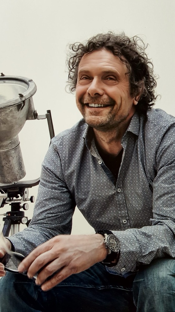 Peter van den Dungen naast een oude filmlamp